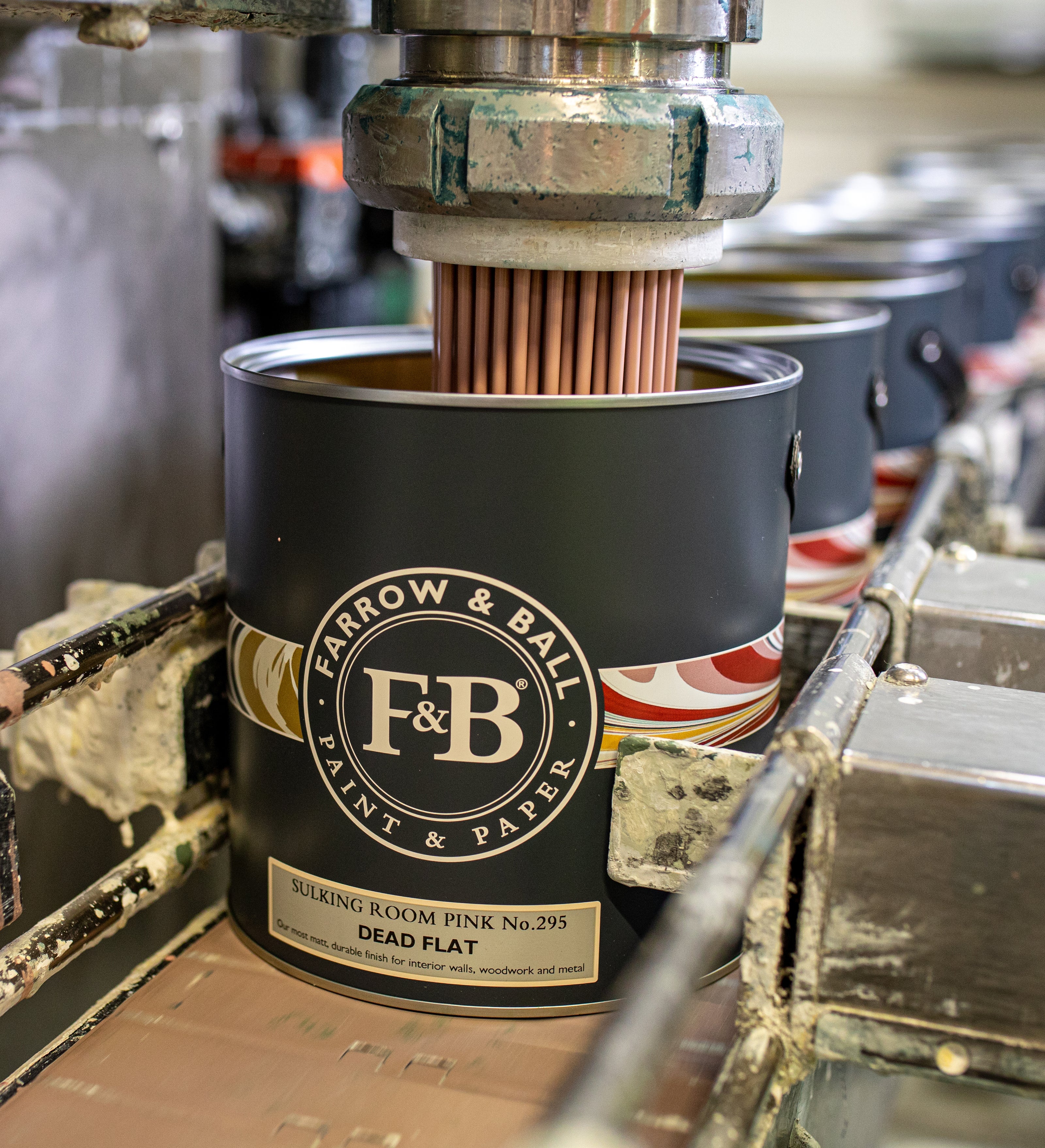 Ein Bild auf dem eine Dead Flat Dose in der Produktion von Farrow & Ball mit Farbe befüllt wird