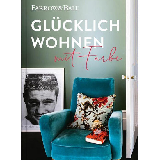 Das Buchcover des Buches "Glücklich wohnen mit Farbe" in Grün mit einem blauem Sessel im Vordergrund