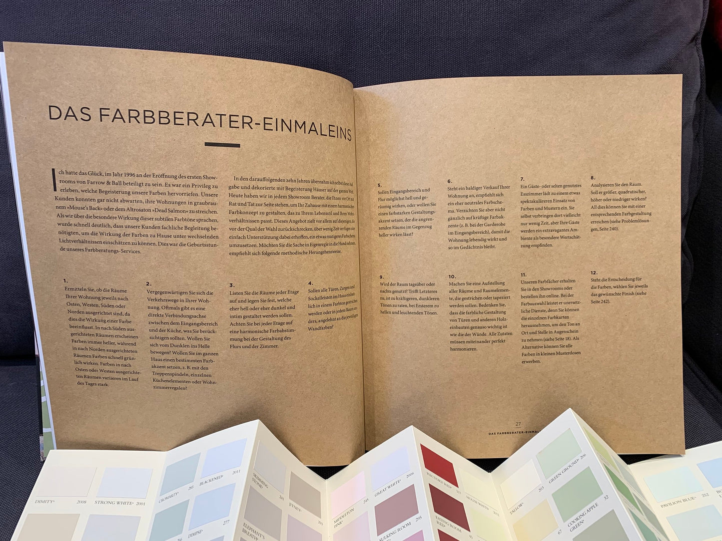 Das Farbberater einmaleins aus dem Buch "Glücklich wohnen mit Farbe". Davor eine offene Farbkarte.