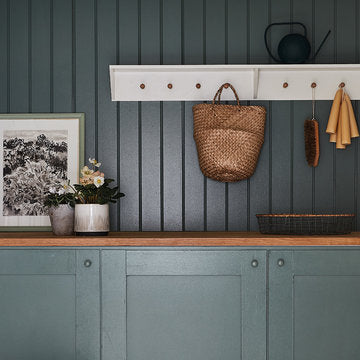 Eine Blau lackierte Holzwand und das passende Sideboard davor.